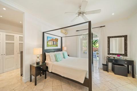 Spacious bedroom with a king-sized bed, stylish décor, and access to a private patio at Ixora, Royal Westmoreland, Barbados