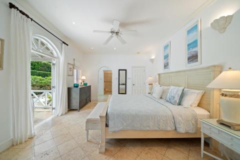 Bedroom with king-sized bed, modern décor, and private patio access with garden views at Ixora, Royal Westmoreland, Barbados