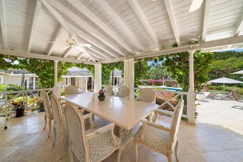 Open-plan dining area with elegant furniture and a stunning view of the pool at Ixora Royal Westmoreland, Barbados