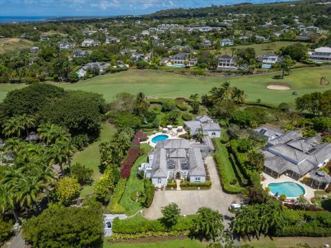 Aerial view of Ixora Royal Westmoreland, Barbados, highlighting the beautiful property, pool, and surrounding lush tropical landscaping
