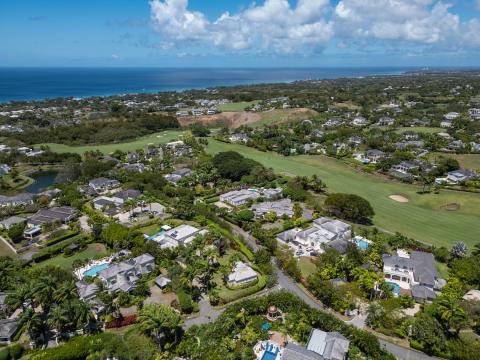Aerial view showcasing the beautiful villas and golf course at Royal Westmoreland, Barbados, with the Caribbean Sea in the distance