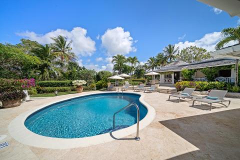 Expansive pool deck at Ixora Villa with lounge chairs, providing a perfect space for sunbathing and enjoying the tropical gardens