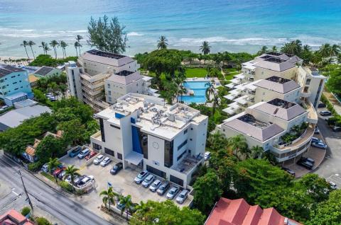 A striking aerial view of Palm Beach 101 in Barbados, showing the resort’s beachfront location, pools, lush gardens, and luxury accommodations.