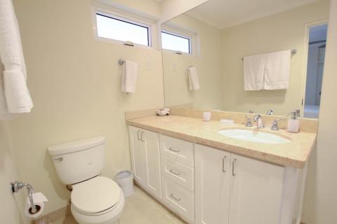 Modern en-suite bathroom at Palm Beach 109, Barbados, with a spacious vanity, stylish finishes, and fresh white towels.