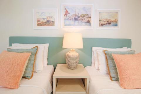 Twin beds in the third bedroom at Palm Beach 109, Barbados, with plush pillows, a bedside lamp, and nautical-themed artwork.