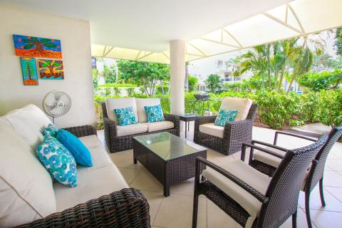 Cozy and stylish patio seating at Palm Beach 109, Barbados, with comfortable wicker lounge chairs and vibrant tropical accents. 