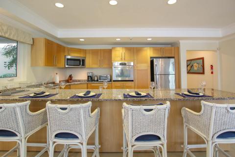 Stylish kitchen at Palm Beach 109, Barbados, with granite countertops, bar seating, and modern stainless steel appliances.
