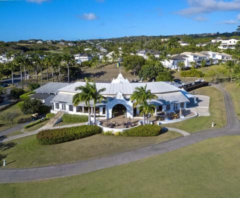 Iconic clubhouse at Royal Westmoreland, Barbados, featuring classic island architecture, a welcoming outdoor terrace, and views of the golf course.