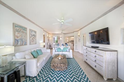 Coastal-themed living space in Sunshine View Penthouse, Sugar Hill Resort, Barbados, with white sofas, a unique driftwood coffee table, and turquoise accents, creating a relaxed yet refined environment ideal for unwinding.