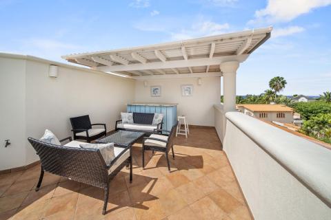 Rooftop lounge area of Sunshine View Penthouse, Sugar Hill Resort, Barbados, with comfortable outdoor seating and a private bar area, perfect for enjoying panoramic views and tropical sunsets.