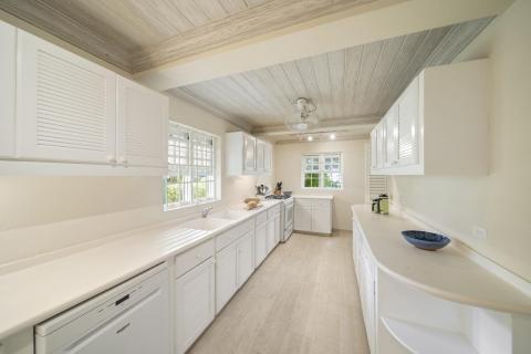 A modern and spacious kitchen at Seascape villa in Barbados, featuring ample counter space, white cabinetry, and a light, airy design perfect for holiday rental convenience.