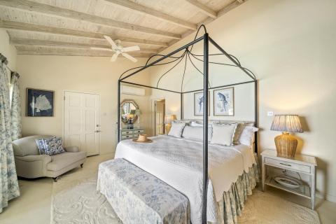Image of the master bedroom with a four-poster bed at Seascape, Barbados: A bright, spacious master bedroom featuring a stunning four-poster bed, vaulted ceilings, and stylish decor, exuding Caribbean charm and providing a tranquil retreat in this luxury Barbados holiday villa.